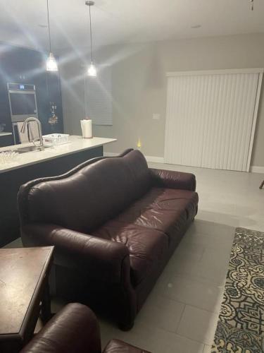 a brown leather couch sitting in a living room at Orlando 4 bedroom built in 2021 in Orlando