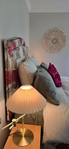 a lamp on a table next to a bed with pillows at Chestnut Bay Country Retreat in Whakamarama