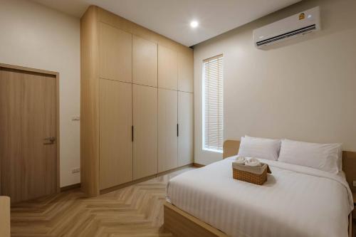 a bedroom with a white bed and a cabinet at Minimalistic Pool Villa in Ao Nang 
