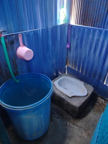a blue bathroom with a bucket and a toilet at Atta komodo homestay in Komodo