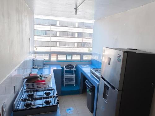 a kitchen with a stove and a refrigerator at Hostal Ciudad de México - Habitaciones privadas en el centro histórico in Mexico City