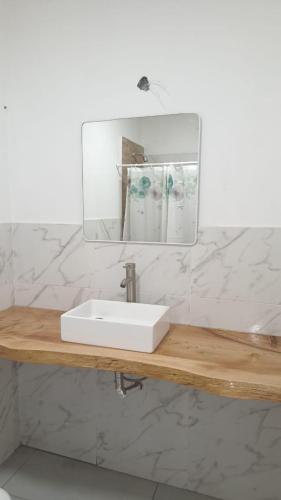 a bathroom with a white sink and a mirror at Macarena in La Falda