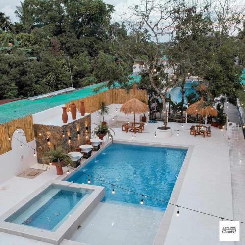 an overhead view of a swimming pool with tables and umbrellas at Villa Soledad Garden Resort in Sampong