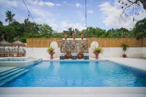 einen Pool im Hinterhof mit einem Holzzaun in der Unterkunft Villa Soledad Garden Resort in Sampong
