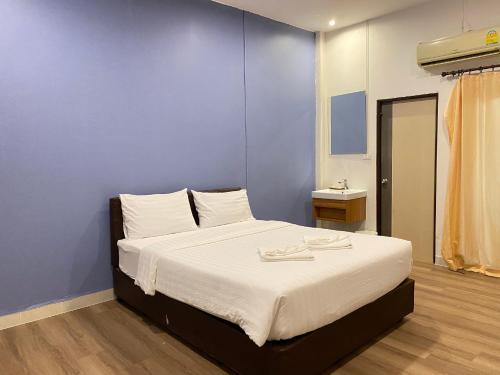 Un dormitorio con una cama con una pared azul. en Crystal Resort Korat, en Nakhon Ratchasima