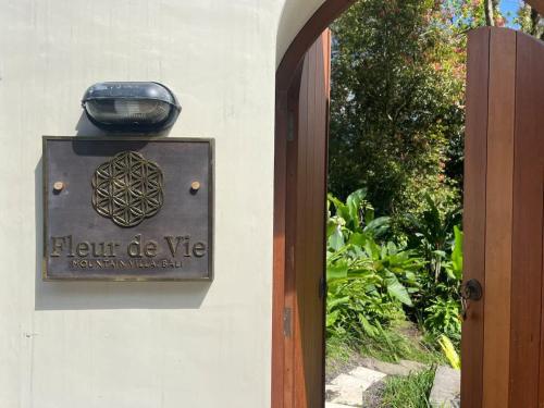 a sign on the side of a building with a light on it at Mountain Villa & Nature Retreat - Fleur de Vie in Bedugul