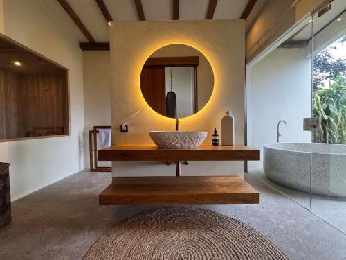 a bathroom with a sink and a tub and a mirror at Mountain Villa & Nature Retreat - Fleur de Vie in Bedugul
