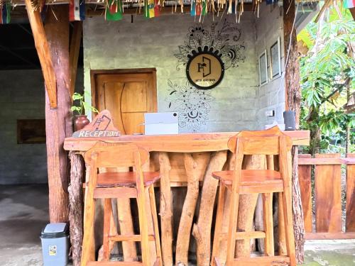 Una mesa de madera con dos sillas y una computadora portátil encima. en Hide and Seek, en Tetebatu