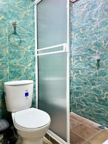 a bathroom with a toilet and a glass shower at El guadual apartahotel in Salento