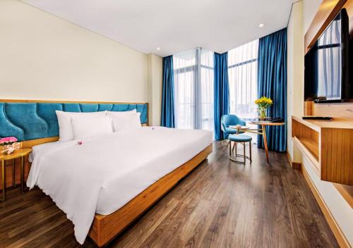 a hotel room with a large bed and a desk at San Marino Boutique Danang - 10 mins to Dragon Bridge & 15 mins to My Khe Beach in Da Nang
