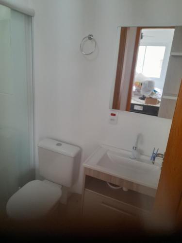 une salle de bains avec toilettes, lavabo et miroir dans l'établissement Apartamento Premium Torres-Rs, à Torres