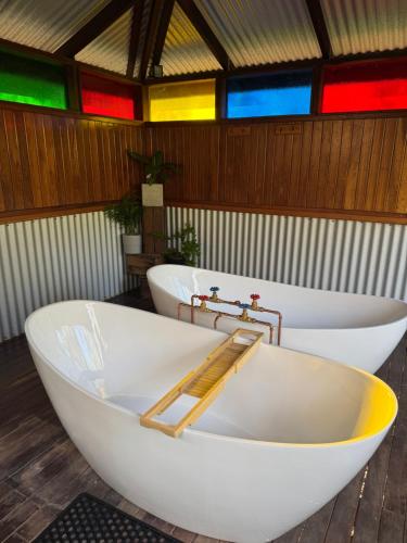 巴林Balingup Jalbrook Cottages Jalbrook Estate的房间里有两个白色浴缸，周围环绕着彩色灯光。