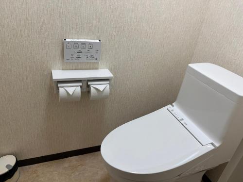 ein Badezimmer mit einer weißen Toilette in einem Zimmer in der Unterkunft 源泉の湯 福の屋 in Minakami