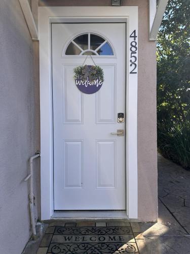 a white door with a welcome sign on it at Cozy Home near Beaches, LAX, SoFi, Intuit Dome,405 in Hawthorne