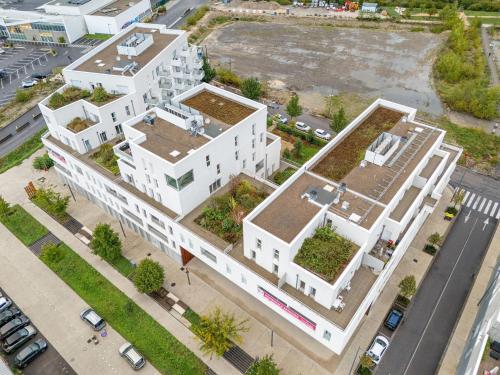 尚贝里Quality Suites Chambéry的从高处俯瞰一座白色建筑，屋顶上长满了植物。