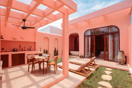 eine Terrasse mit einem Tisch und Stühlen in einem Haus in der Unterkunft Villa Solea in Gili Trawangan