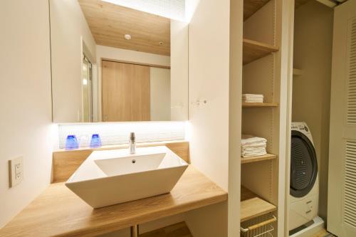a bathroom with a sink and a mirror at BEB5 Okinawa Seragaki by Hoshino Resorts in Onna