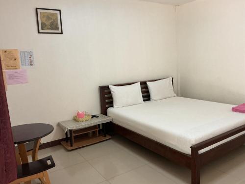 una piccola camera da letto con un letto e un tavolo di Pruksa Resort Prachin Buri a Prachin Buri