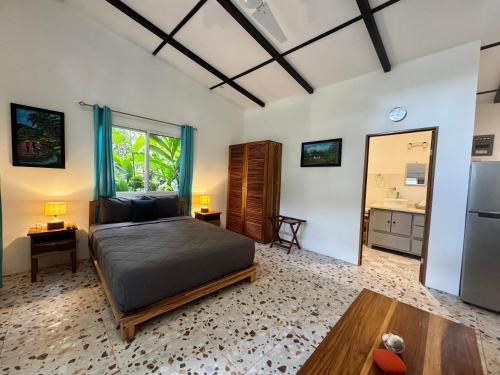 Casita Azul Studio with shared swimming pool في بونتا أوفا: غرفة نوم بسرير ومغسلة وثلاجة