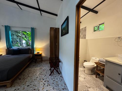 Casita Azul Studio with shared swimming pool في بونتا أوفا: غرفة نوم بسرير وحمام مع مرحاض