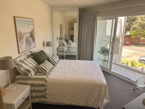 a bedroom with a bed and a large window at 150m to Dee Why Beach in Deewhy