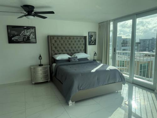 een slaapkamer met een bed en een plafondventilator bij Isla Verde Beach Dreamscape in San Juan