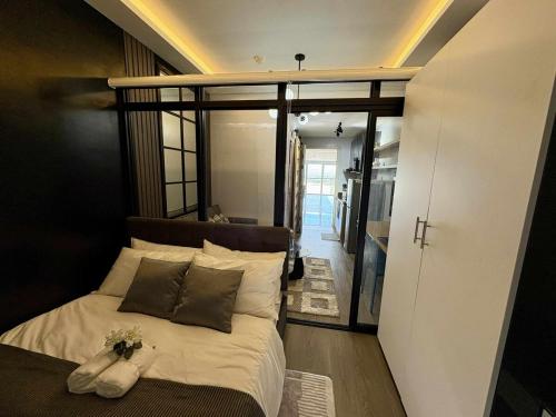 a bedroom with a bed with a flower arrangement on it at Cozy Sunset Condo Thompson Stay in Manila