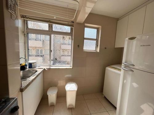 a small kitchen with a sink and a refrigerator at Apt Praia Mansa Don in Matinhos