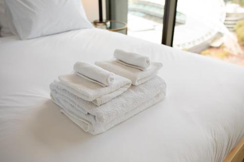 two towels are stacked on top of a bed at SkyHaus - City & Fireworks View 2 Bed Apartment in Sydney