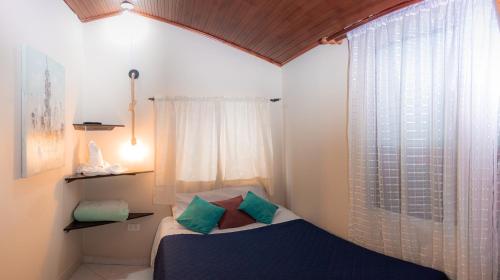 a small bedroom with a bed and a window at hotel Dinastia in Tunja