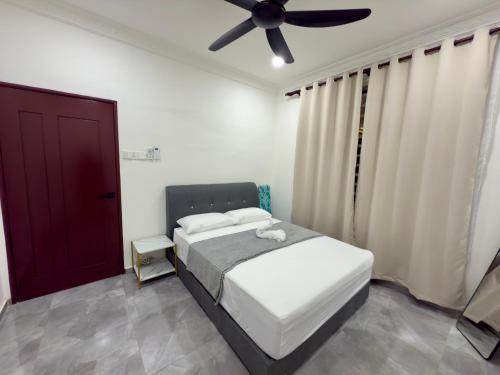 a bedroom with a bed and a ceiling fan at Vs Homestay Semambu Kuantan in Kuantan