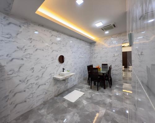 a dining room with a table and a white wall at Vs Homestay Semambu Kuantan in Kuantan