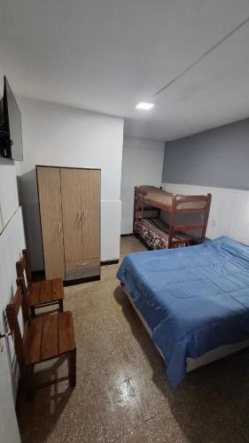 una camera con letto, armadio e sedie di Hospedaje Artigas a Corrientes