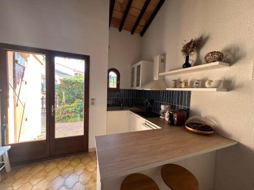 a kitchen with a counter and a large window at Villa T2 Mezzanine, 5 pers, à 600m de la plage. Animaux admis. - FR-1-793-36 in Saint Cyprien Plage