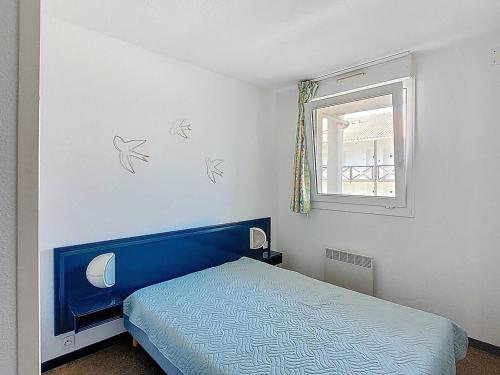 Appartement T3 à Vieux-Boucau, 6 pers, terrasse et parking - FR-1-857-25 في فيو بوكو لي بان: غرفة نوم بسرير ازرق ونافذة