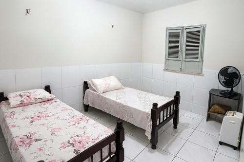 um quarto com duas camas e uma janela em Casa de Temporadas Alto Bonito em Luis Correia