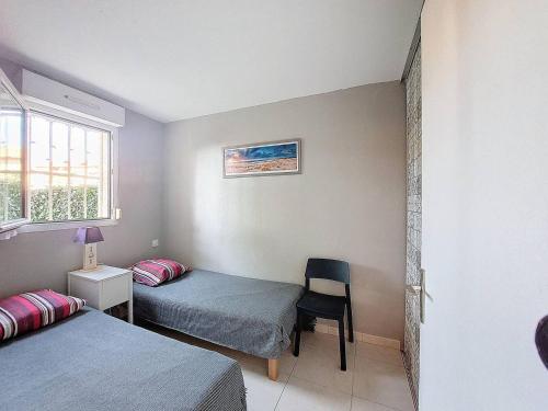 T2 Soustons Plage 4 pers avec Loggia - FR-1-857-38 في فيو بوكو لي بان: غرفة بسريرين وكرسي ونافذة