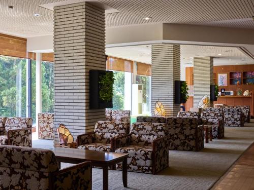 a waiting room with couches and tables in a building at Misasa Royal Hotel in Misasa