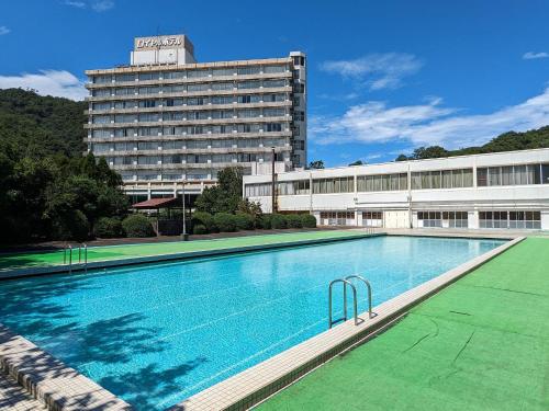 a large swimming pool in front of a building at Misasa Royal Hotel in Misasa