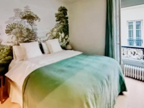 a bedroom with a green and white bed and a window at Center ,gare Montparnasse,5 minute Eiffel tout and Louvre Meusm,amusing place in Paris