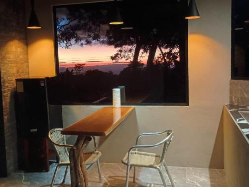 Tamara Monteverde View and Forest Chalet في مونتيفيردي كوستاريكا: طاولة وكرسيين في مطبخ مع نافذة