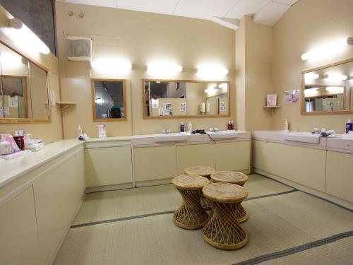 三朝町にある三朝ロイヤルホテルの洗面台2つとスツール2つを備えたバスルーム