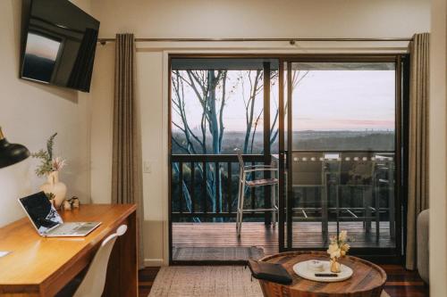 MudgeerabaNebesa的客房设有书桌和滑动玻璃门