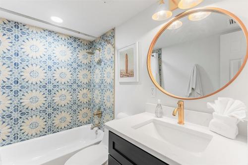 Un baño con un lavabo blanco y un espejo. en Spanish Main, en Cocoa Beach