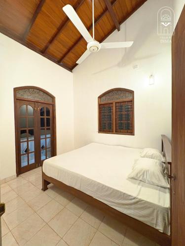 a bedroom with a bed and a ceiling fan at Villas by DIMA in Galle