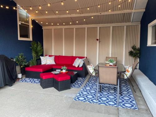 un patio con divano rosso, tavolo e sedie di Blue Raptor Family-Friendly 3BR Private Yard a Drumheller