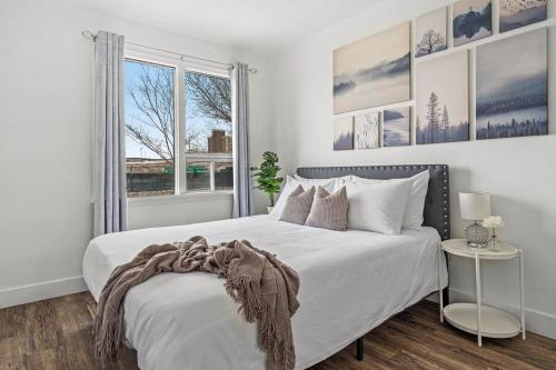 una camera da letto bianca con un letto grande e una finestra di Blue Raptor Family-Friendly 3BR Private Yard a Drumheller