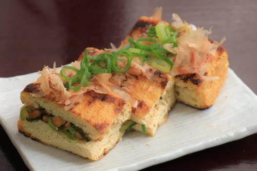 twoasted sandwiches on a white plate with green onions at Court Hotel Niigata in Niigata