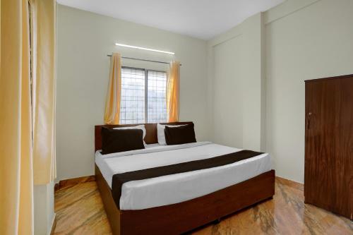 a bedroom with a large bed with a window at Super Hotel O Symbiosis University Nagpur Formerly Royal Villa Inn in Sakardarā