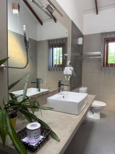 a bathroom with a sink and a toilet and a mirror at Hotel Heladiv in Anuradhapura